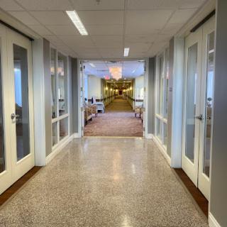 A view down a well-lit corridor with glass doors on either side.