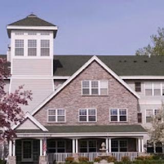 A beautiful multi-family residential building with a distinctive tower and charming architecture.