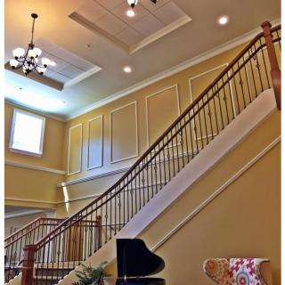 Elegant interior with a grand staircase and chandelier.