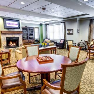 A cozy living room with a fireplace, seating area, and table set for games.