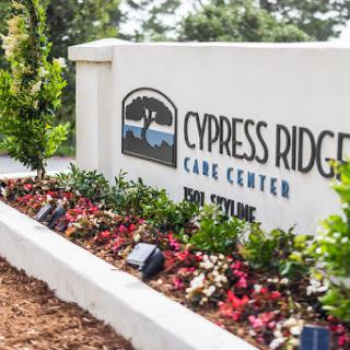 Entrance sign of Cypress Ridge Care Center surrounded by colorful landscaping.