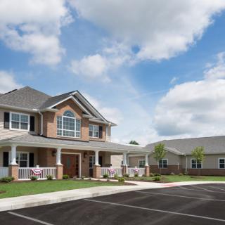 A suburban residential building under a partly cloudy sky.