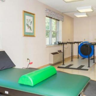 A physical therapy room equipped with various exercise tools and a therapy bed.