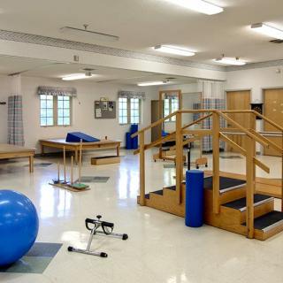 A physical therapy room equipped with exercise equipment and therapy tools.