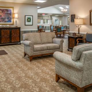 A cozy lobby area featuring sofas, a carpeted floor, and warm lighting.