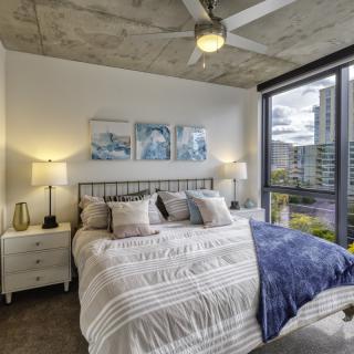 A modern, cozy bedroom with large windows and stylish decor.