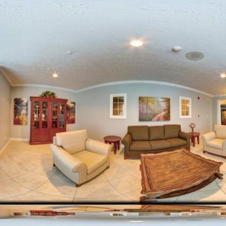 A spacious living room with modern furniture and decorative artwork on the walls.