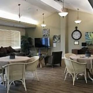 A cozy living and dining area with comfortable seating, tables, and a television.