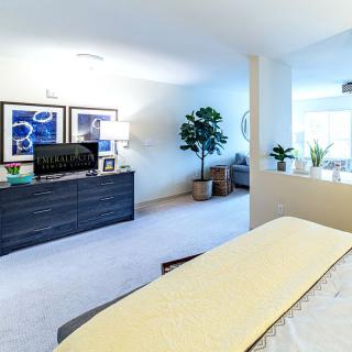 A modern bedroom with stylish furniture, decor, and indoor plants.