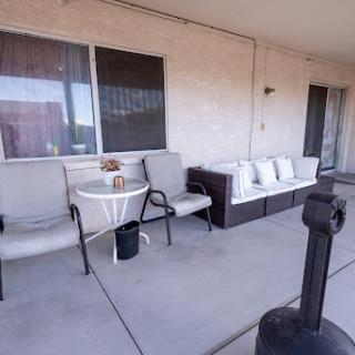 A cozy outdoor patio setup featuring comfortable seating and a small table.