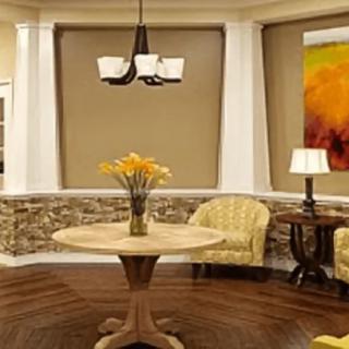 A cozy living room with a round table and comfortable chairs, adorned with warm lighting and decor.