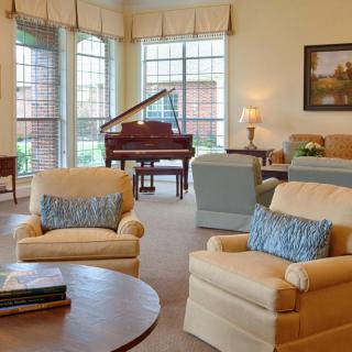 A cozy living room featuring comfortable seating and a grand piano.