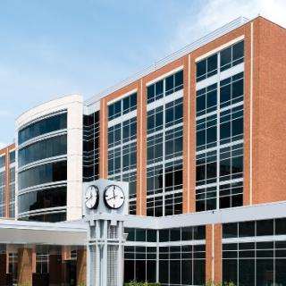 A modern building with a prominent clock and expansive glass windows.