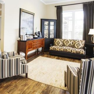 Cozy living room with patterned furniture and wooden floors.