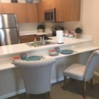 Modern kitchen with a breakfast counter and stainless steel appliances.