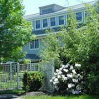 A residential building with a lush garden and blooming flowers.