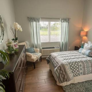 A cozy bedroom with a neatly made bed, soft lighting, and elegant decor.