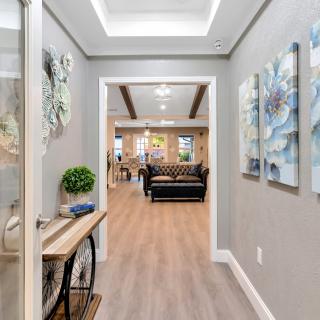 A modern hallway with artwork and stylish furnishings leading into a living space.