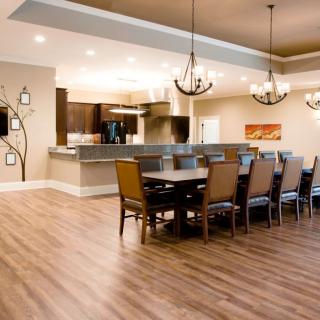 A spacious and modern open-plan dining area with wood flooring and elegant chandeliers.