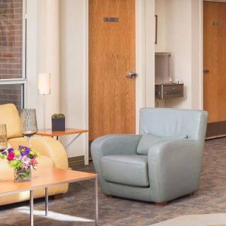 A cozy lobby area featuring comfortable seating and a floral arrangement.