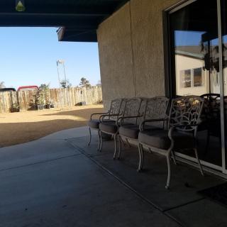 A sunny patio with chairs lined up outside a building.