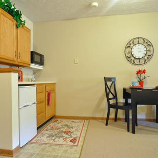 A cozy kitchen and dining area with wooden cabinets, a dining table, and wall decor.