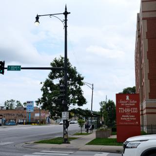 An urban street scene featuring a traffic light and signage near a building.