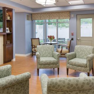 A cozy waiting room with comfortable armchairs and a small table by the window.