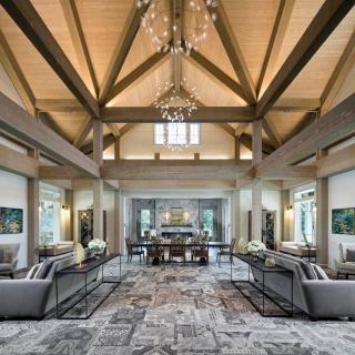A luxurious and spacious living room with a vaulted ceiling and elegant chandelier.