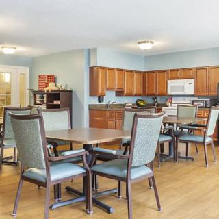 A spacious kitchen and dining area with wooden cabinets, tables, and chairs.