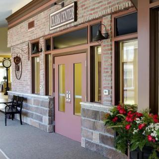 A charming storefront entrance adorned with flowers and a bench.