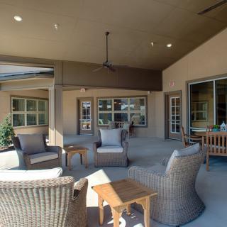 A cozy covered patio area with wicker chairs and a table for relaxation.