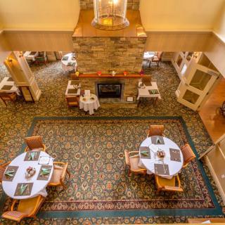 A cozy restaurant interior with neatly arranged tables and a central fireplace.