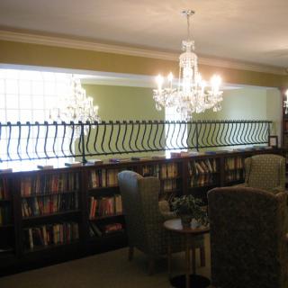 A cozy library space with chandeliers and bookshelves lining the walls.