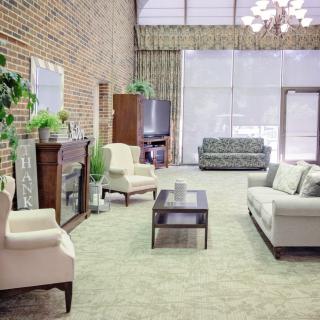 A spacious living room with modern furniture and a brick accent wall.