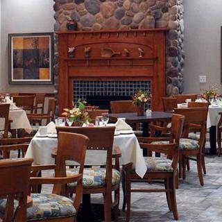 A cozy restaurant dining area with neatly arranged tables and a fireplace.