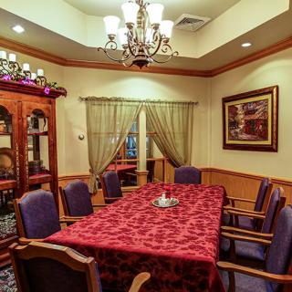 A warmly lit dining room with a red tablecloth and elegant decor.