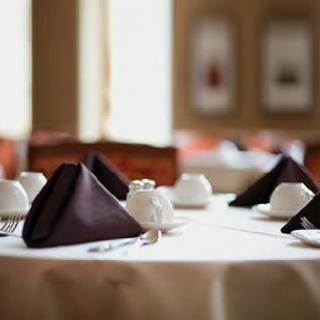 A beautifully set table in a restaurant, featuring neatly folded napkins and elegant tableware.