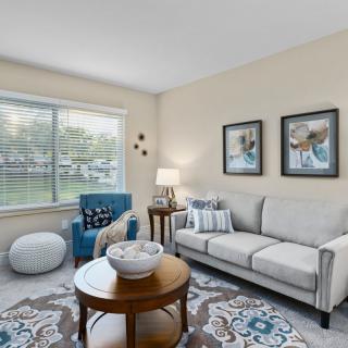 A cozy living room featuring a sofa, armchair, and coffee table with decorative accents.