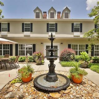 A charming house with a central fountain and well-maintained garden.