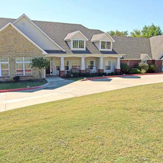 A spacious suburban house with a well-maintained lawn and driveway.