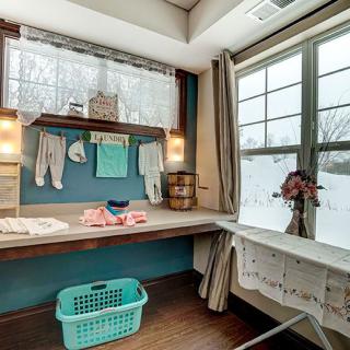A cozy laundry room with a clothesline by the window and a laundry basket on the floor.
