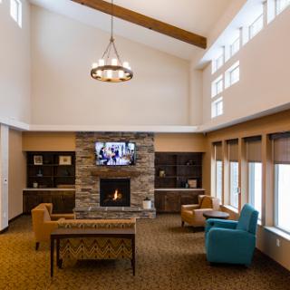 A spacious and inviting lobby area featuring a fireplace, comfortable seating, and ample natural light.