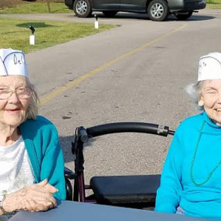 Two cheerful elderly women enjoying a sunny day together.