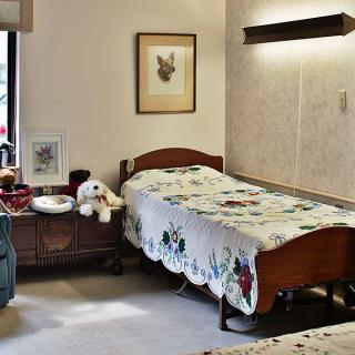 A cozy bedroom with a single bed, nightstand, and wall decorations.