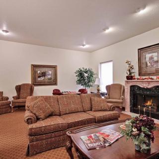 A cozy living room with a sofa, armchairs, and a fireplace.