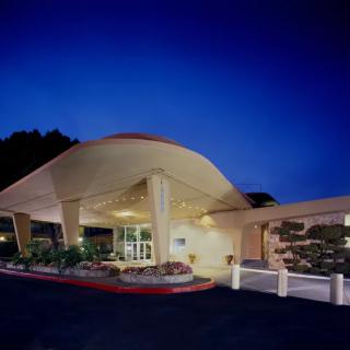 A modern hotel entrance illuminated beautifully against the night sky.