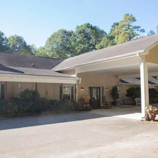 A beautiful residential house with a landscaped yard and a clear blue sky.
