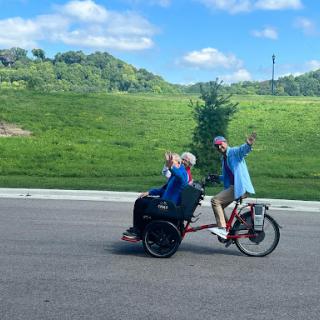 Two friends enjoying a ride on a bicycle in a scenic outdoor setting.