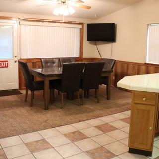 A cozy dining room with a table, chairs, and a wall-mounted television.